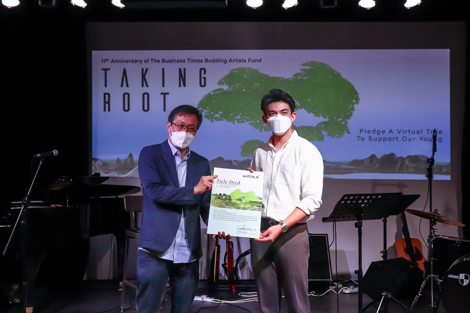 Chairman of BT BAF, Wong Wei Kong (left) receiving the Title Deed for the 2 hectares of virtual real estate from director of business development of HATTENX, Edern Tan.