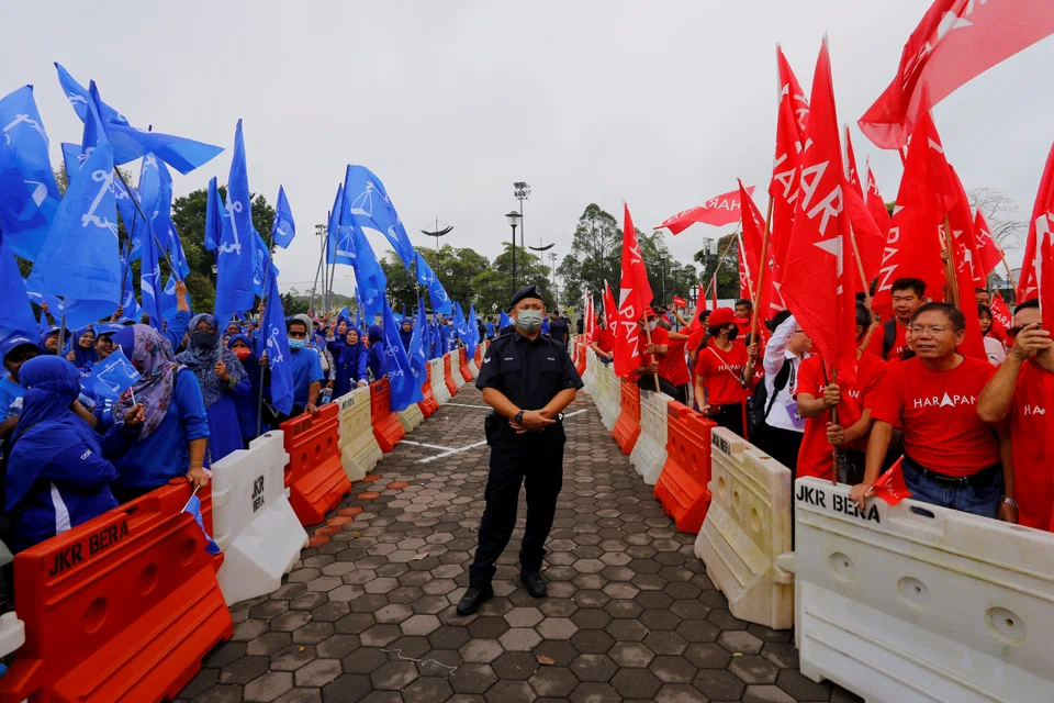 A police stands guard between supporters of The National Front coalition, Barisan Nasional, and The Alliance Of Hope, Pakatan Harapan, outside a nomination centre on nomination day in Bera, Pahang, Malaysia. 