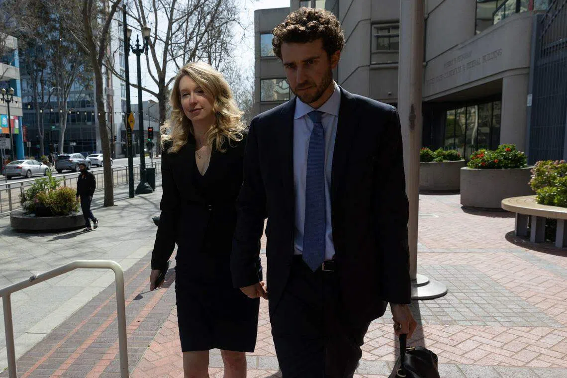 Theranos founder Elizabeth Holmes leaving a federal courthouse accompanied by her partner Billy Evans, after asking a US judge at a hearing to pause her prison sentence of more than 11 years while she urges an appeals court to review her conviction on charges of defrauding investors in her blood-testing startup.