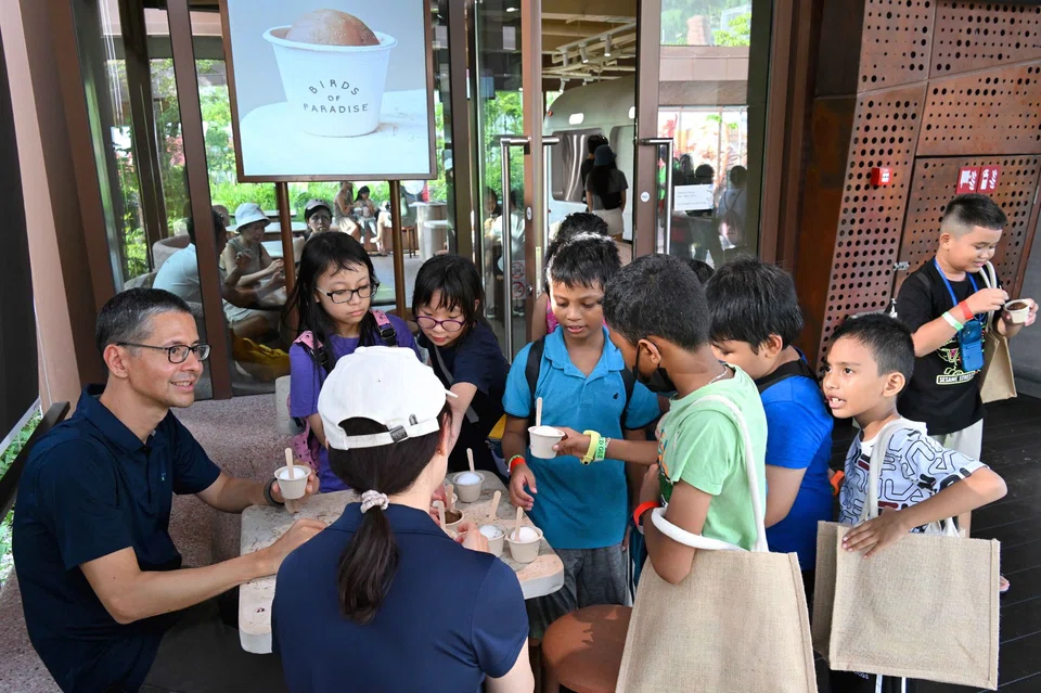 Standard Chartered's Patrick Lee (left) with some of the children who visited the recently opened Bird Paradise. Taking less-privileged children to Asia's largest bird park is part of the bank's aim to promote social inclusion and create a better community through volunteerism.
