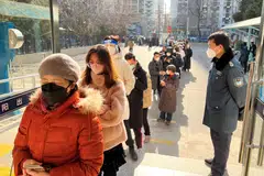 People lining up at a government office to renew their passports after China dropped border controls.
