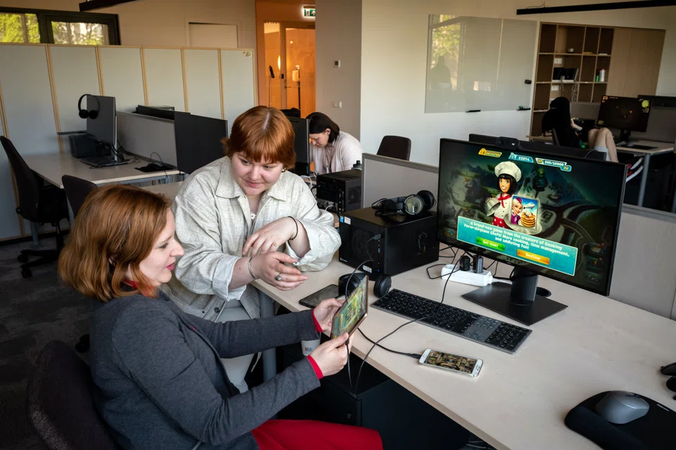 Inha Kushnir, left, and Nastya Dahno working at the headquartes of the game maker Nordcurrent in Vilnius, Lithuania, on May 23, 2022. They were among the employees in Ukraine that were evacuated by the company as Russia invaded. 