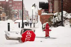 A knocked down "Stop" sign lies across a sidewalk following a winter storm in Buffalo, New York, US, Dec 27, 2022. 