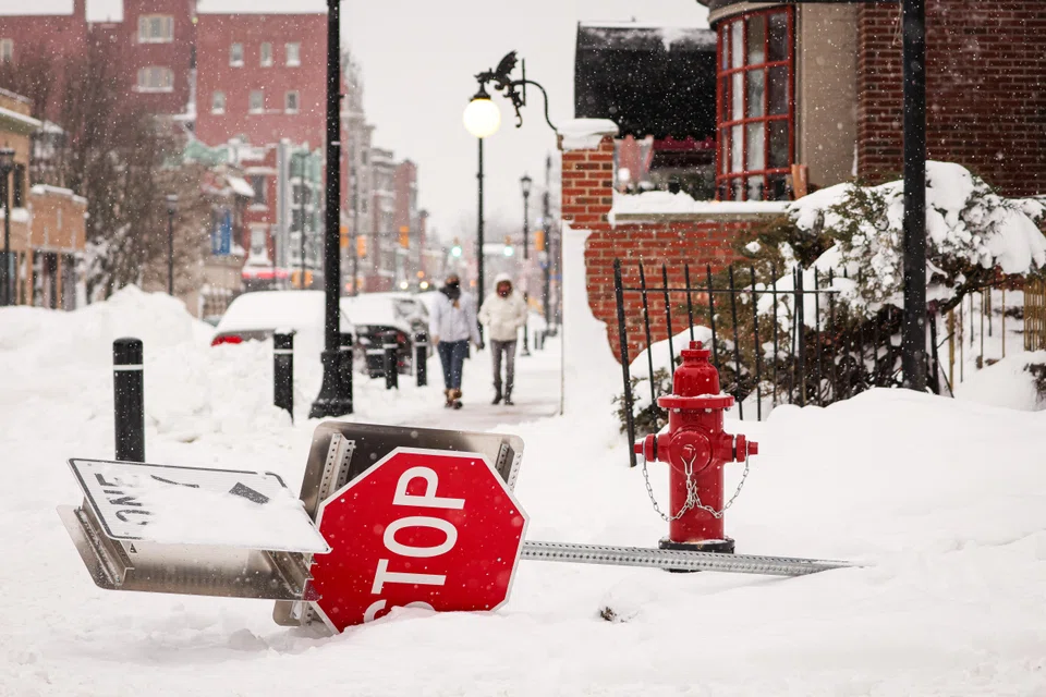 A knocked down "Stop" sign lies across a sidewalk following a winter storm in Buffalo, New York, US, Dec 27, 2022. 
