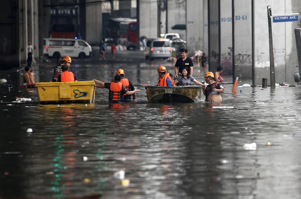Emergency response teams use rafts to help transport residents along a flooded road in Quezon City, Philippines, after it was hit by Typhoon Saola. Hong Kong is making preparations for a possible direct hit by the typhoon.