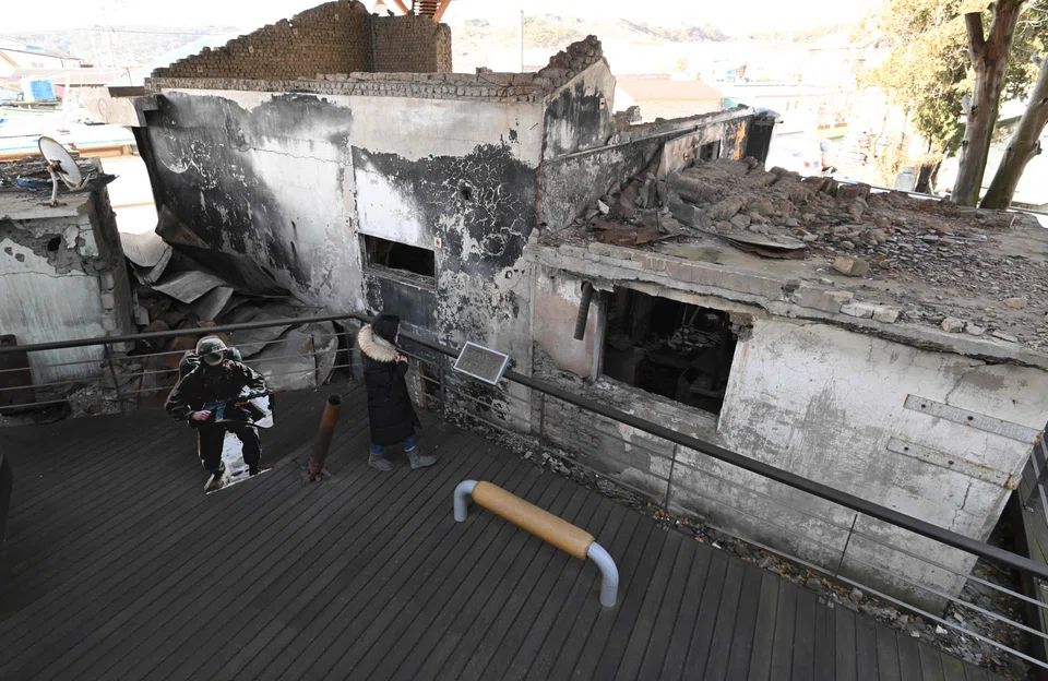 A woman looking at wrecked homes hit by North Korea's 2010 shelling attack at a museum that displays materials related to the attack on Yeonpyeong island, near the 'northern limit line' sea boundary with North Korea.