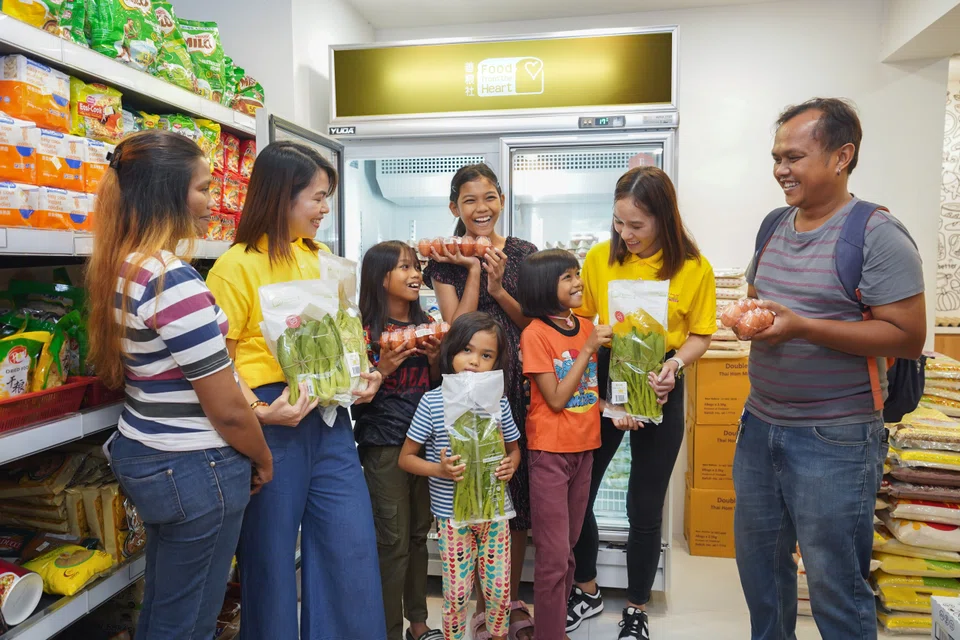 RWS staff volunteers (second from left and second from right) with homemaker Siti Rosninah (far left) and her family.