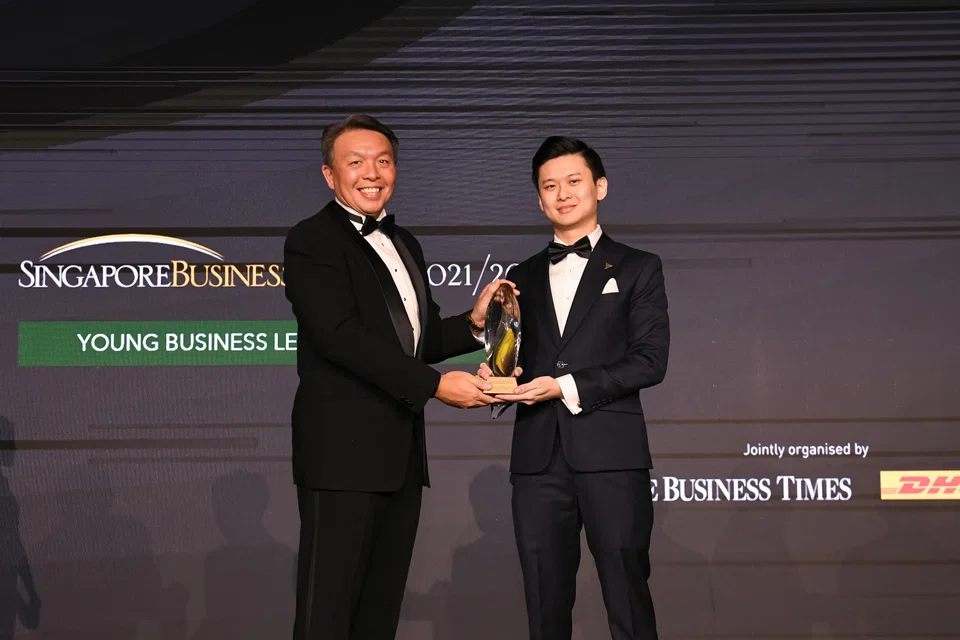 Christopher Ong (left), senior vice­-president & managing director, DHL Express Singapore, presenting the trophy for the Young Business Leader of the Year award to Ian Ang, co-­founder and CEO  of Secretlab SG.