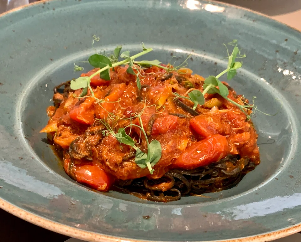 Squid ink pasta in a tomato-based crabmeat sauce