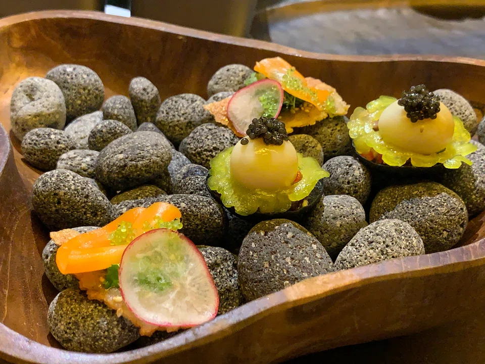 Sisig (right) are delicious morsels of pig's head, liver and salted egg topped with a smoked quail egg.