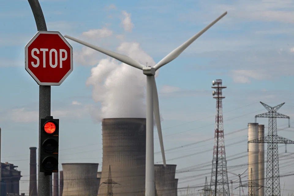 A wind turbine is seen in front of a coal-fired power plant operated by German energy supplier RWE in Niederaussem, Germany. Energy think tank Ember said renewable energy sources prevented a possible 4 per cent increase in power generation from polluting fossil fuels.