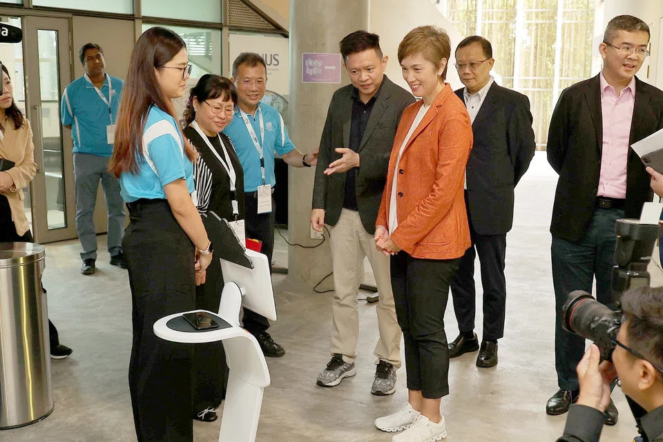 Communications and Information Minister Josephine Teo (in an orange blazer) at the 5G Learning Festival. She says the JTM will guide employers in "providing the necessary training or reskilling for workers to take an evolved or an emerging job role".