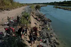 Members of the Texas National Guard try to dissuade migrants from climbing over the razor wire after they crossed the Rio Grande in Eagle Pass, Texas.