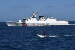 A Filipino fisherman (front) sailing past a Chinese coast guard ship near the China-controlled Scarborough Shoal, in disputed waters of the South China Sea, Feb 16, 2024. Maritime security - and China’s increasingly aggressive behaviour in the South China Sea - figures to be one of Asean's major focal points.