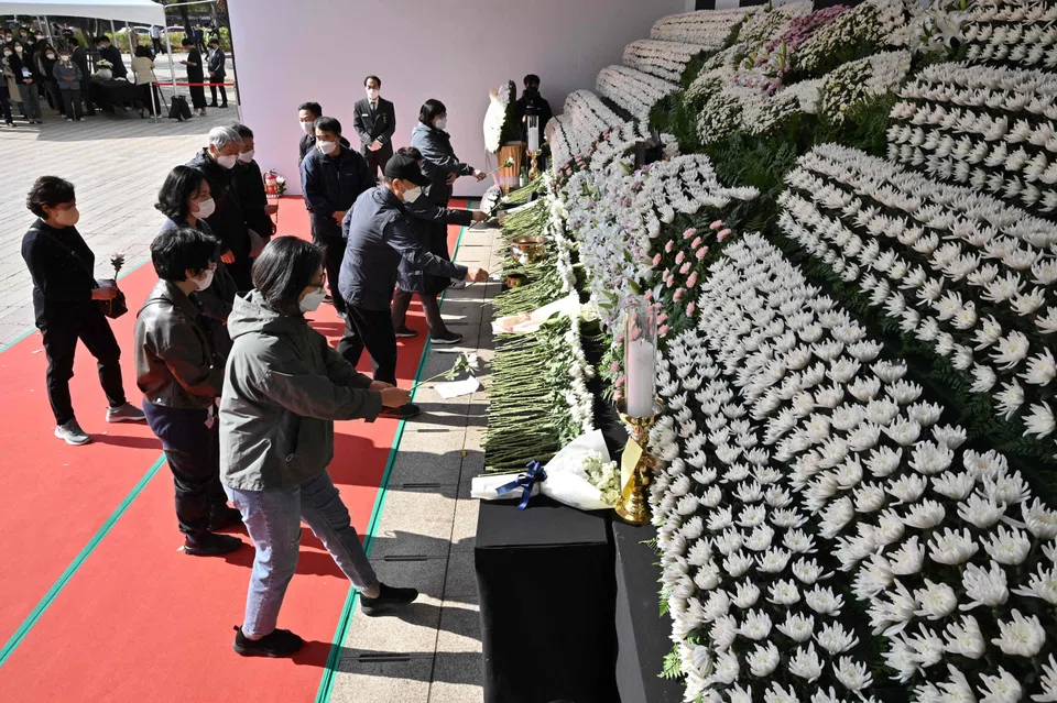 Mourners pay tribute in front of a joint memorial altar for victims of the deadly Halloween crowd surge in Seoul on Oct 31, 2022. 