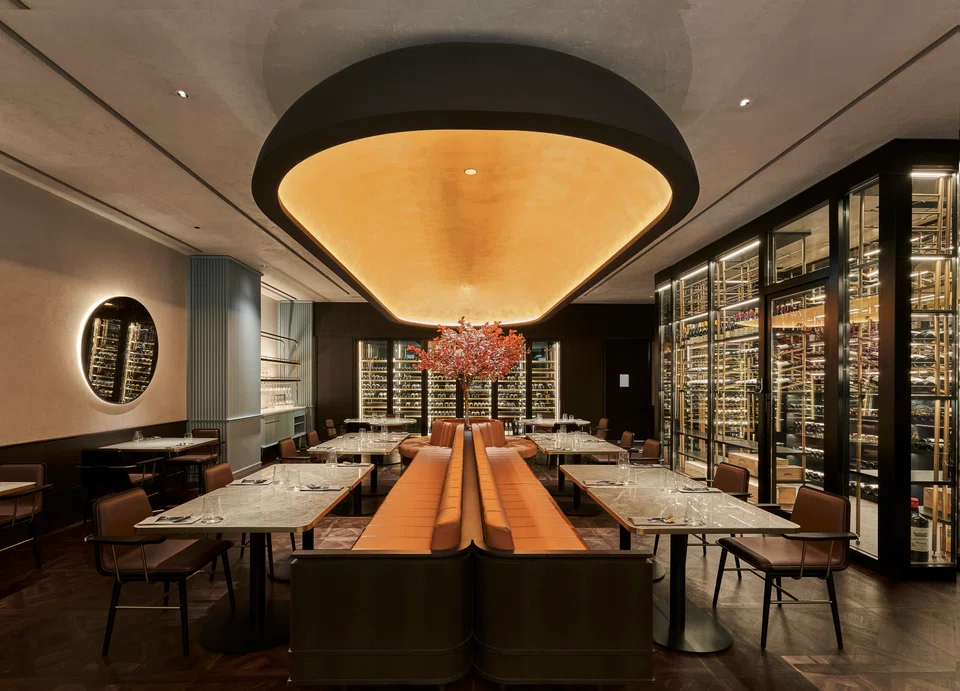 The main dining room features an all-black interior and warm lighting.