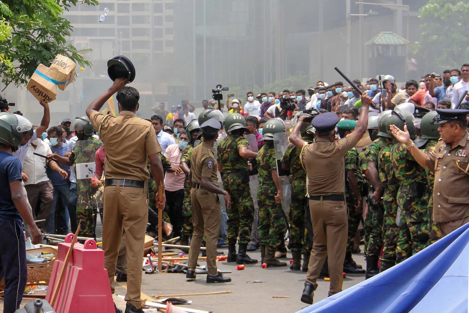 Paramilitary personnel and police arriving at a protest site as demonstrators and government supporters clash outside the President's office in Colombo on Monday.  