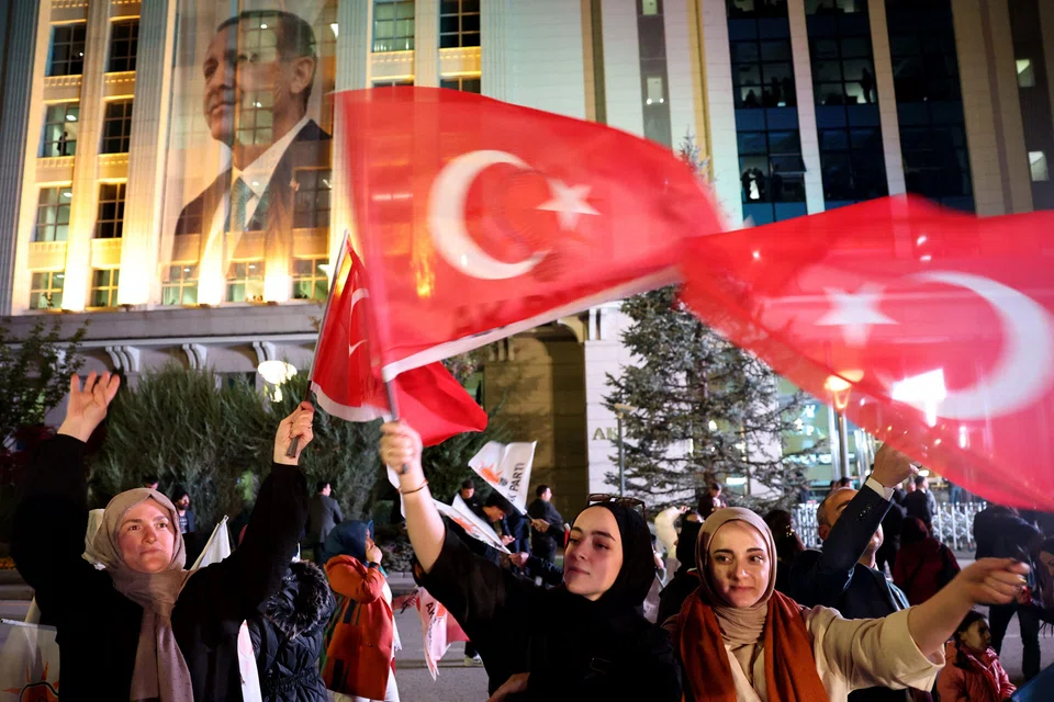 Supporters of Turkish President Recep Tayyip Erdogan and AK Party (AKP) wave flags at the AK Party headquarters in Ankara, Turkey, May 14, 2023. 