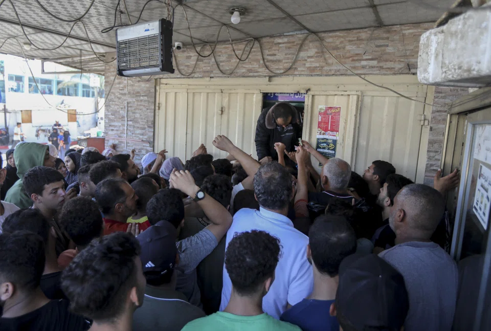 People queue in line to buy bread in Khan Younis, Gaza, on Oct 15, 2023. 
