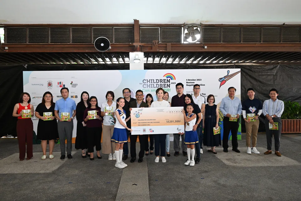 Minister for Communications and Information Josephine Teo (centre, in white) witnesses the cheque presentation to The Business Times Budding Artists Fund.  With her are the sponsors and organisers of Children For Children. 
