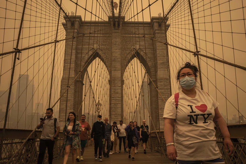 Pedestrians cross the Brooklyn Bridge as smoke from wildfires in Quebec blanketed New York on June 7, 2023. 