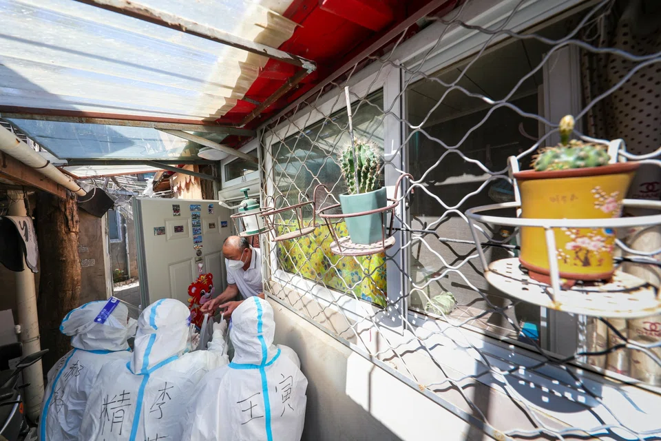 Volunteers deliver food supplies to residents at a residential community under restrictions in Beijing on Jun 5. 