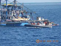 China Coast Guard personnel onboard a rigid-hulled inflatable boat (right) shadow a Philippine fishing boat (left) during the Philippine Bureau of Fisheries and Aquatic Resources mission to bring supplies to fishermen near the China-controlled Scarborough Shoal in the disputed South China Sea, Feb 22, 2024.