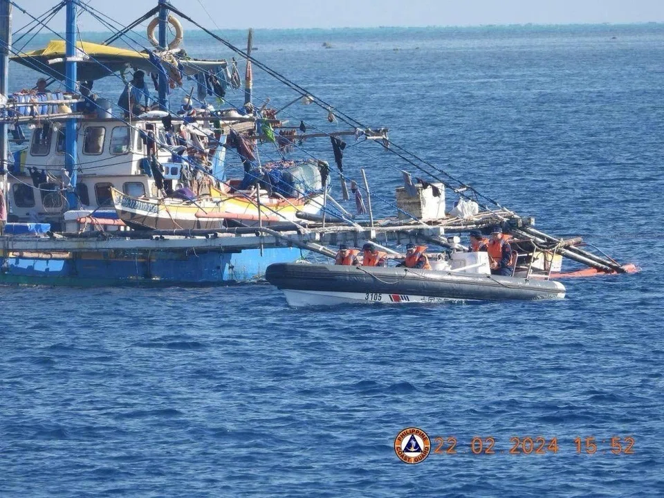 China Coast Guard personnel onboard a rigid-hulled inflatable boat (right) shadow a Philippine fishing boat (left) during the Philippine Bureau of Fisheries and Aquatic Resources mission to bring supplies to fishermen near the China-controlled Scarborough Shoal in the disputed South China Sea, Feb 22, 2024.