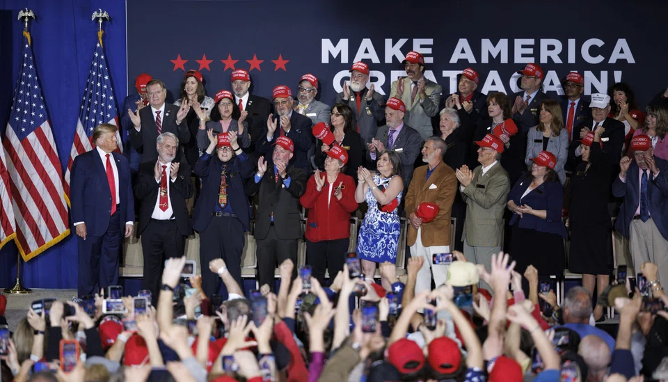 Former US president Donald Trump (left) takes the stage with New Hampshire Republican leaders, before addressing a crowd during a rally in Manchester, New Hampshire, USA, April 27, 2023.  