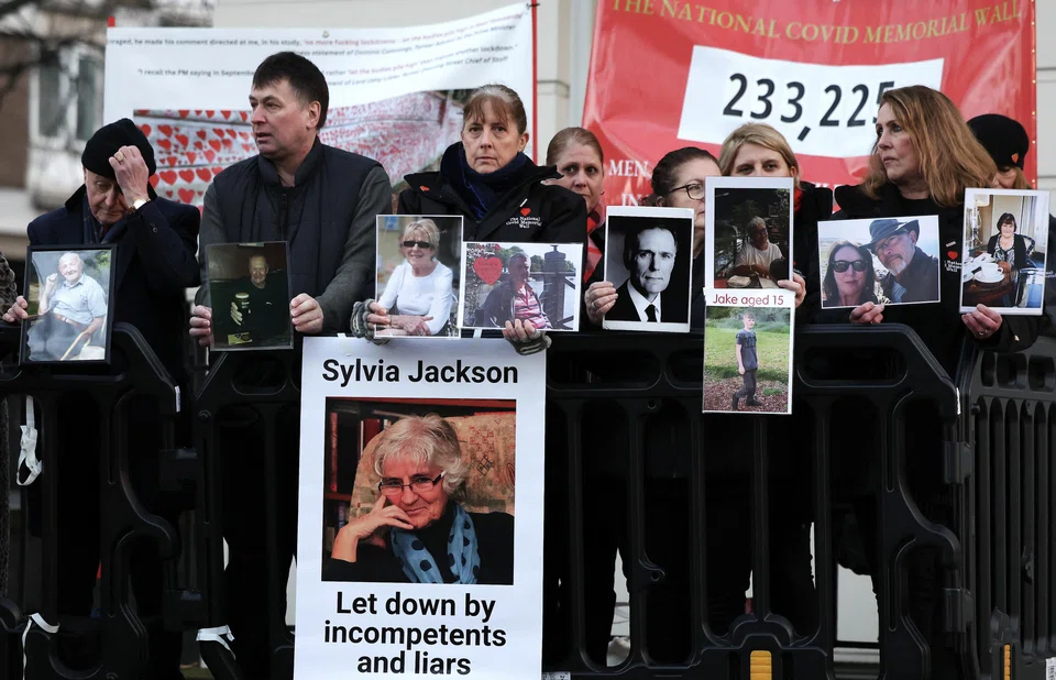 Bereaved family members hold photographs of lost loved ones outside the UK Covid-19 Inquiry in London. They wanted to confront Johnson over claims that he told colleagues he would prefer to see people die in large numbers than order a second lockdown.