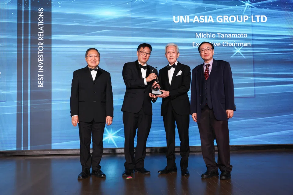 Executive chairman of Uni-Asia Group Michio Tanamoto receiving the trophy for Best Investor Relations award (Silver) from The Business Times editor Wong Wei Kong. Accompanying them are Lee Suan Hiang of SID (left) and Prof Lawrence Loh, director of CGS, Centre for Governance and Sustainability, NUS Business School (right). 
