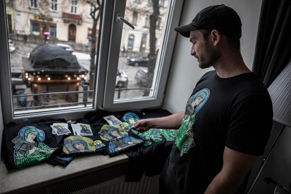 The Canadian entrepreneur Christian Borys with some of the T-shirts and stickers sold by his Toronto-based online business, which has raised US$1.5 million for the Ukrainian charity Help Us Help.