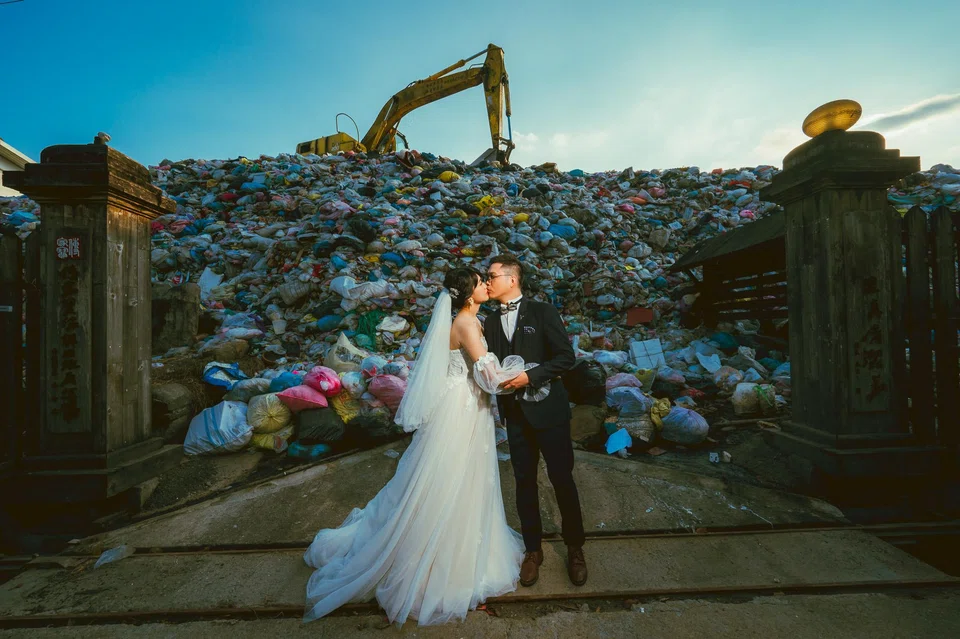 Iris Hsueh and her fiance Ian Ciou posing for a photograph in front of a garbage hill in Puli Township, Nantou County. 