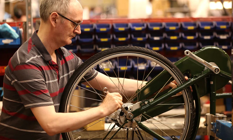A worker assembling a bike at the Pashley bicycle factory in Stratford-upon-Avon in Britain. Manufacturers face weak global market conditions, rising uncertainty, high transportation costs and longer lead times, leading to cancelled orders. said S&P Global. 