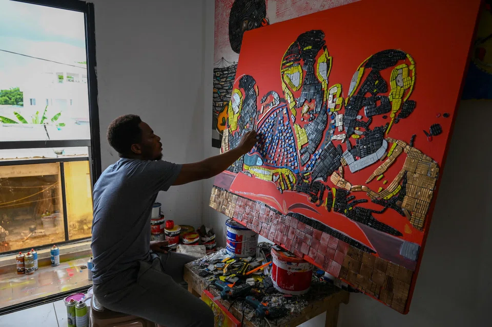 Ivorian artist Mounou Desire Koffi making an artwork with used telephone keyboards at his residence in Bingerville.