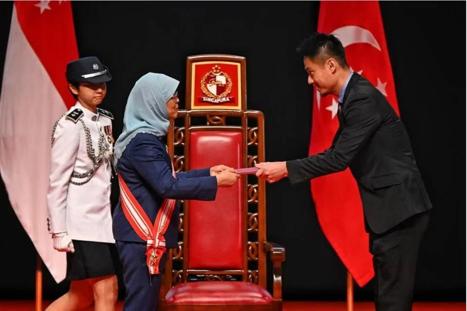 ST chief photojournalist Kevin Lim receiving the President’s Certificate of Commendation (Covid-19) on behalf of SPH Media Trust from President Halimah Yacob.