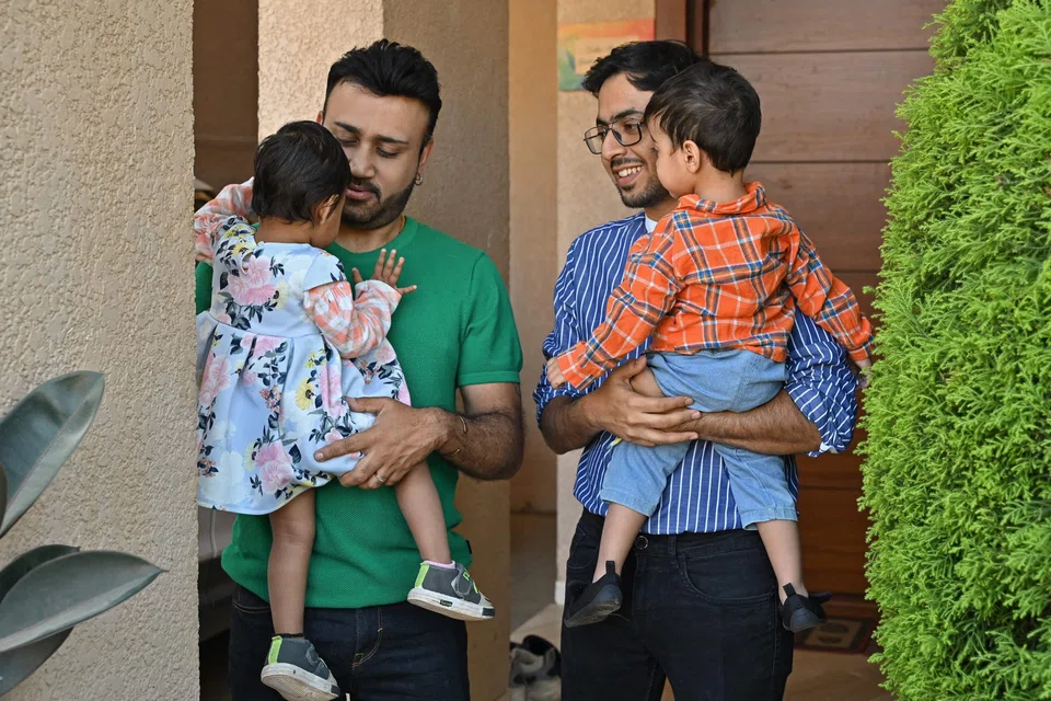Same-sex couple Sougata Basu (L) and Mayank Kalra take their adopted children for a walk outside their home in Bengaluru. A five-judge bench will be hearing appeals to legalise same-sex marriage from Tuesday.