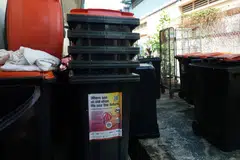 Bins for the shoe recycling programme outside a Yok Impex warehouse. Ten of the original 11 pairs of shoes have been traced to the Singaporean textile and shoe trader, before leaving Singapore's borders for Indonesia.