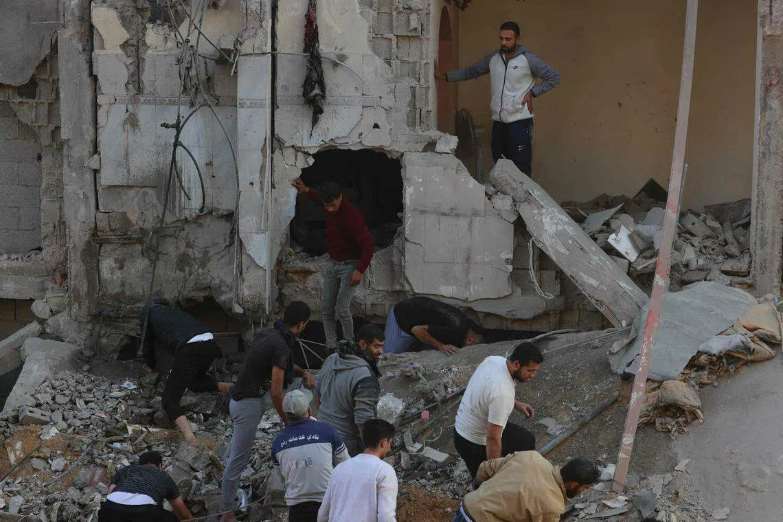 Palestinians inspect the destruction following an Israeli strike in Rafah in the southern Gaza Strip on Dec 1, 2023, as fighting resumed shortly after the expiration of a seven-day truce between Israel and Hamas militants. 