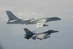 This file handout photo taken and released on February 10, 2020 by Taiwan's Defence Ministry shows a Taiwanese F-16 fighter jet flying next to a Chinese H-6 bomber (top) off the coast of Taiwan. 