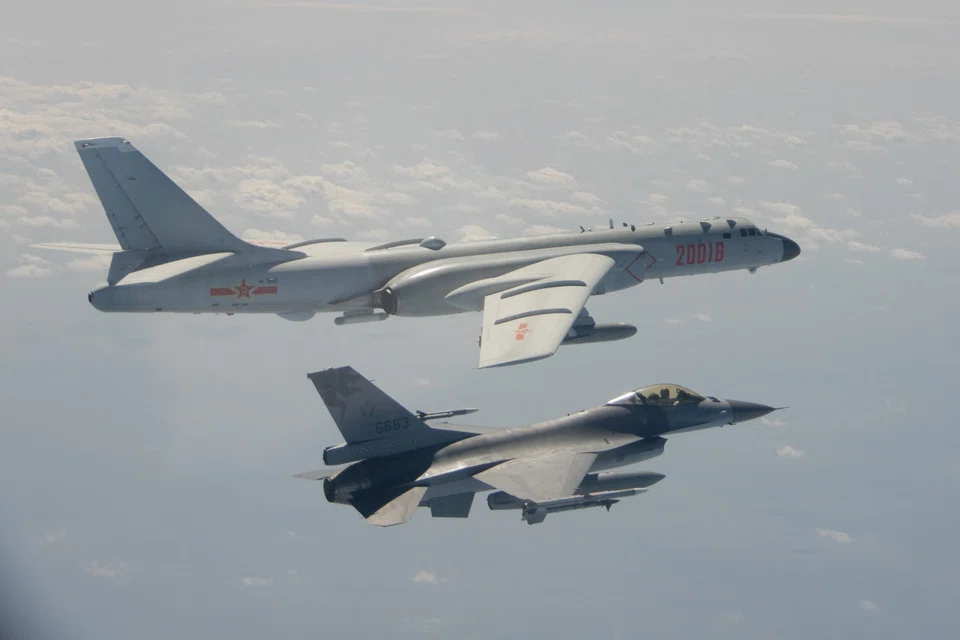 This file handout photo taken and released on February 10, 2020 by Taiwan's Defence Ministry shows a Taiwanese F-16 fighter jet flying next to a Chinese H-6 bomber (top) off the coast of Taiwan. 