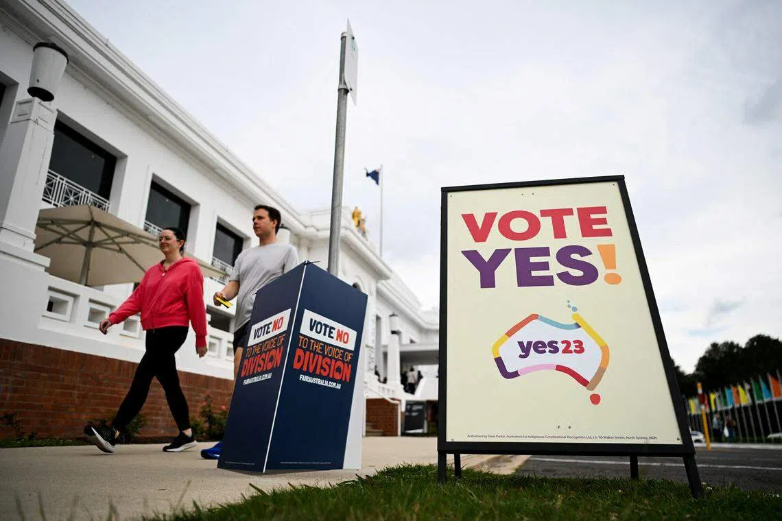 Voters walk past Vote 'Yes' and Vote 'No' signs at the Old Australian Parliament House, during The Voice referendum in Canberra, Australia on Oct 14. 