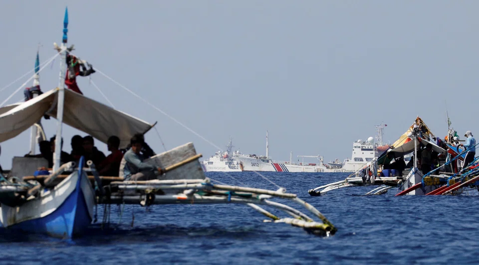 China Coast Guard vessels patrol past Philippine fishing boats at the disputed Scarborough Shoal that both China and the Philippines claim as their own.