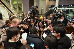 Members of the media surround a passenger that was onboard the Airbus SE A350-900 aircraft, operated by Japan Airlines, that caught fire on landing, at Haneda Airport in Tokyo, Japan, Jan 2, 2024. 