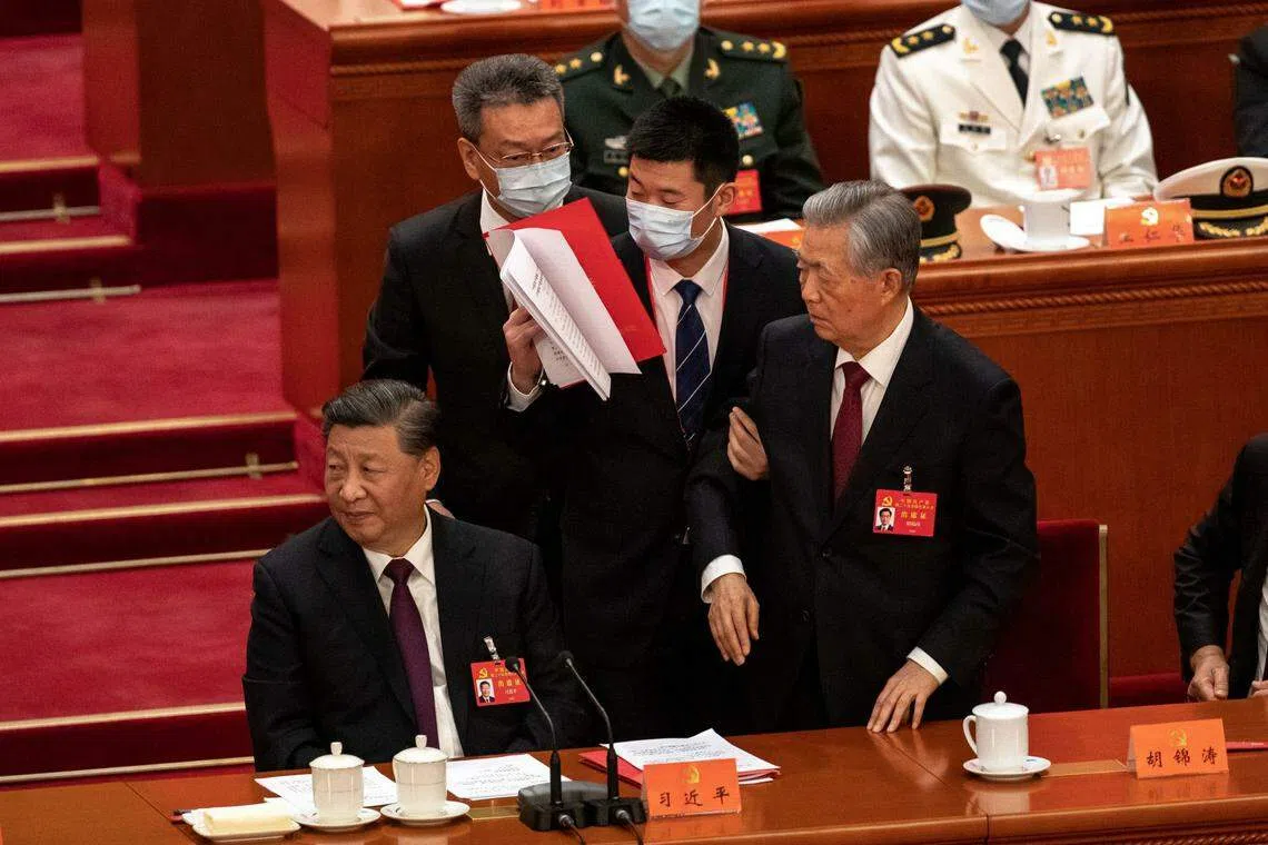 Former Chinese president Hu Jintao leaves his seat next to Chinese President Xi Jinping during the closing ceremony of the 20th National Congress of the Communist Party of China, at the Great Hall of the People in Beijing, China October 22, 2022. 