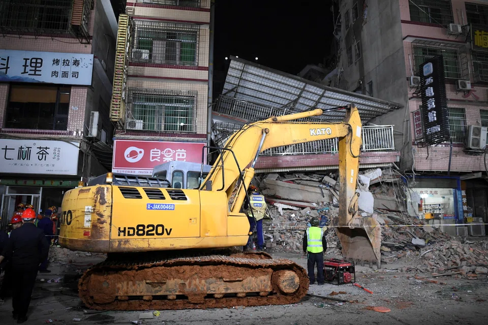 Rescuers work next to an excavator at a site where a building collapsed in Changsha, Hunan province, China on April 29, 2022. 