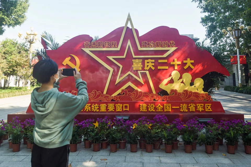 A resident taking photos of an installation welcoming China's 20th Communist Party Congress in Hangzhou in China's eastern Zhejiang province.
