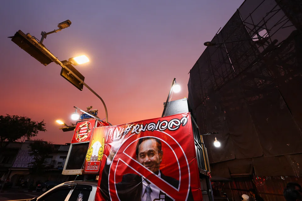 Protesters gather next to a picture of Thailand's Prime Minister Prayuth Chan-ocha outside the Government House, as the Constitutional Court suspended Prime Minister Prayuth Chan-ocha from official duties on Wednesday, after deciding to hear a petition to review his legally mandated eight-year term limit, in Bangkok, Aug 24, 2022. 