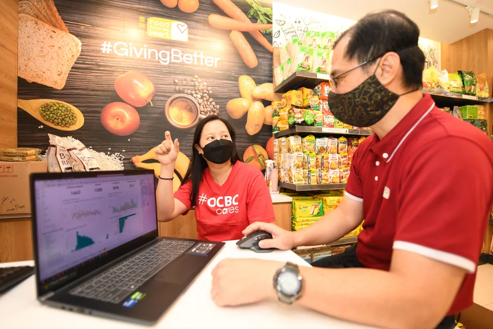 OCBC staff volunteer Pamela Peh working with Food from the Heart’s senior manager of IT and facilities Timothy Lai to analyse data for community shops.