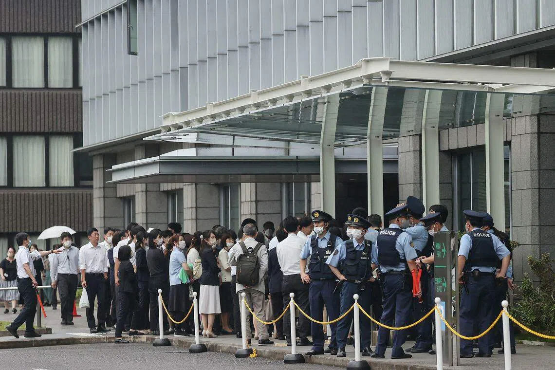 Staff members stand outside the Nara District Court after temporarily evacuating from the building after a suspicious object was delivered during the pre-trial hearing for Tetsuya Yamagami, the man accused of killing Japan's former prime minister Shinzo Abe, in Nara on June 12, 2023. 